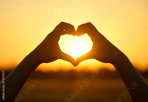 love shape hand silhouette at sunset