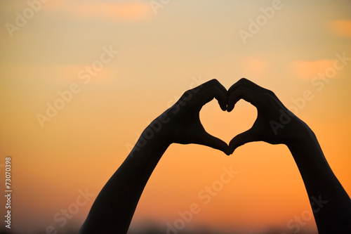 love shape hand silhouette at sunset