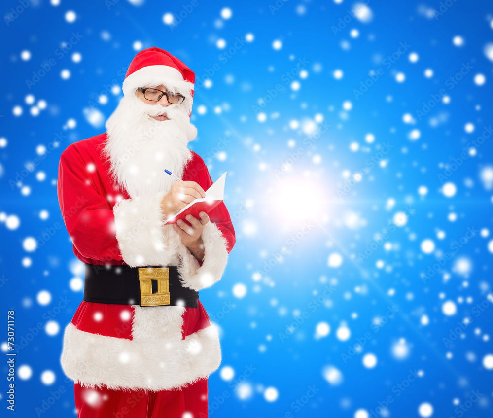 man in costume of santa claus with notepad man in costume of santa claus with notepad