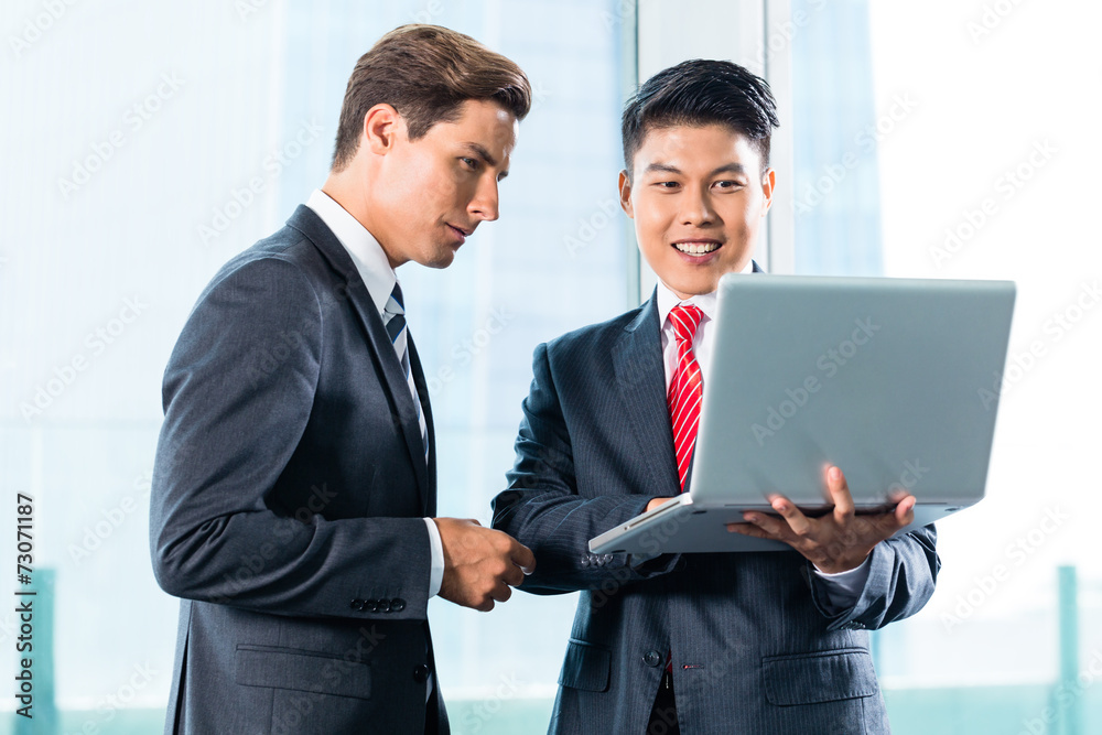 Two Business men with laptop and city skyline Two Business men with laptop and city skyline
