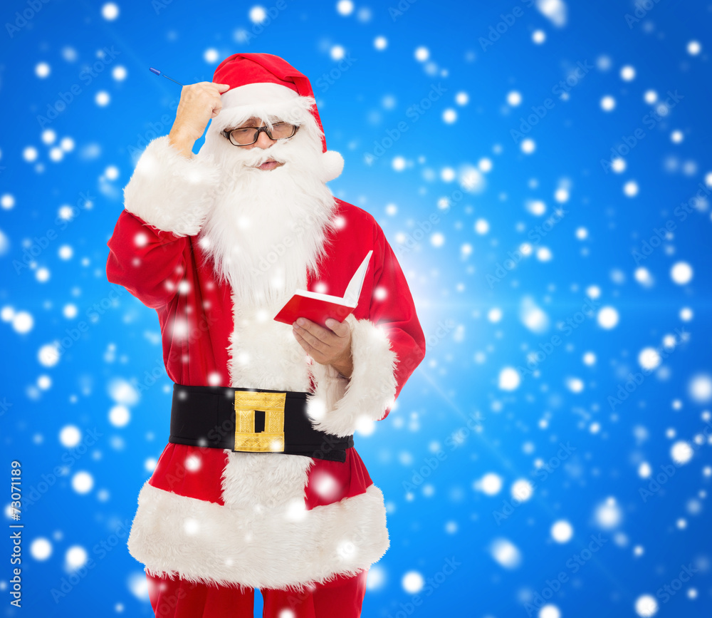 man in costume of santa claus with notepad man in costume of santa claus with notepad