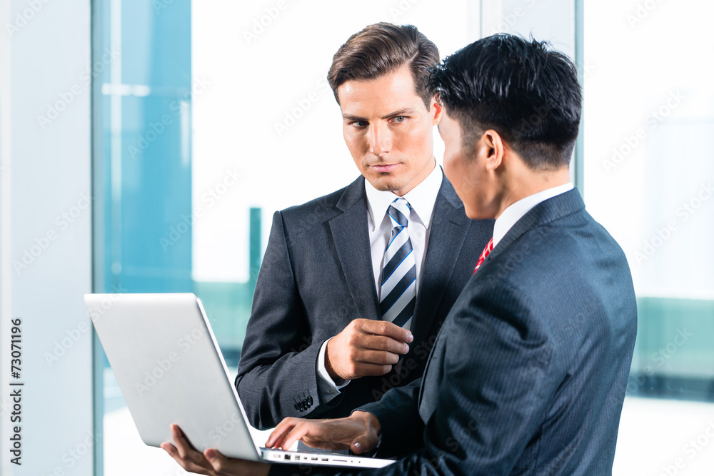 Two Business men with laptop and city skyline Two Business men with laptop and city skyline