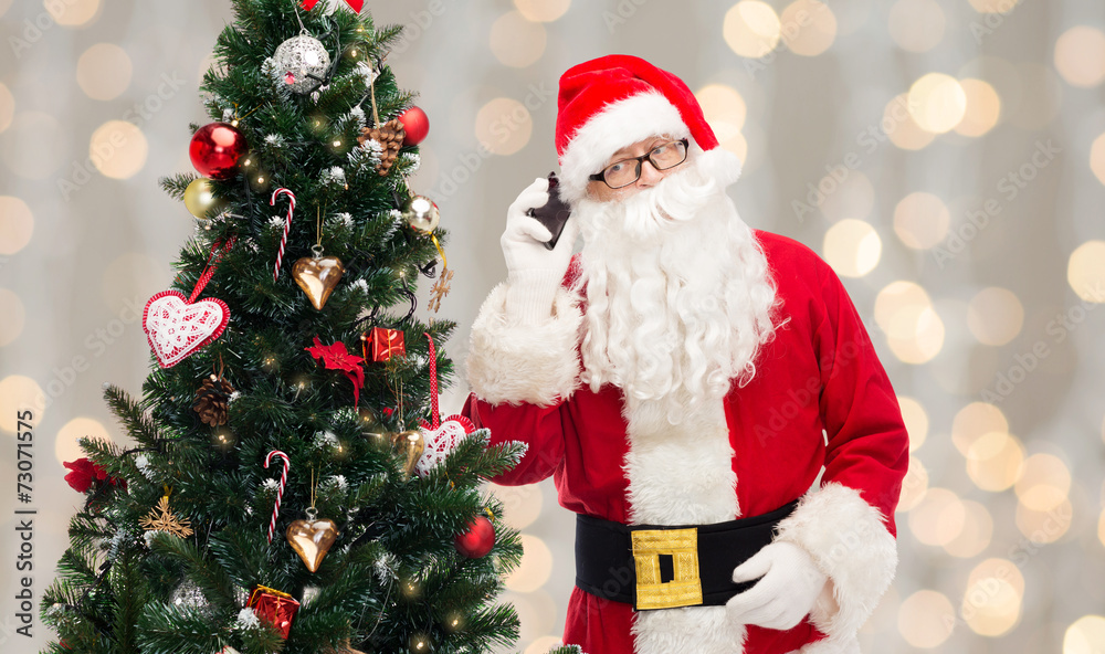 santa claus with smartphone and christmas tree santa claus with smartphone and christmas tree