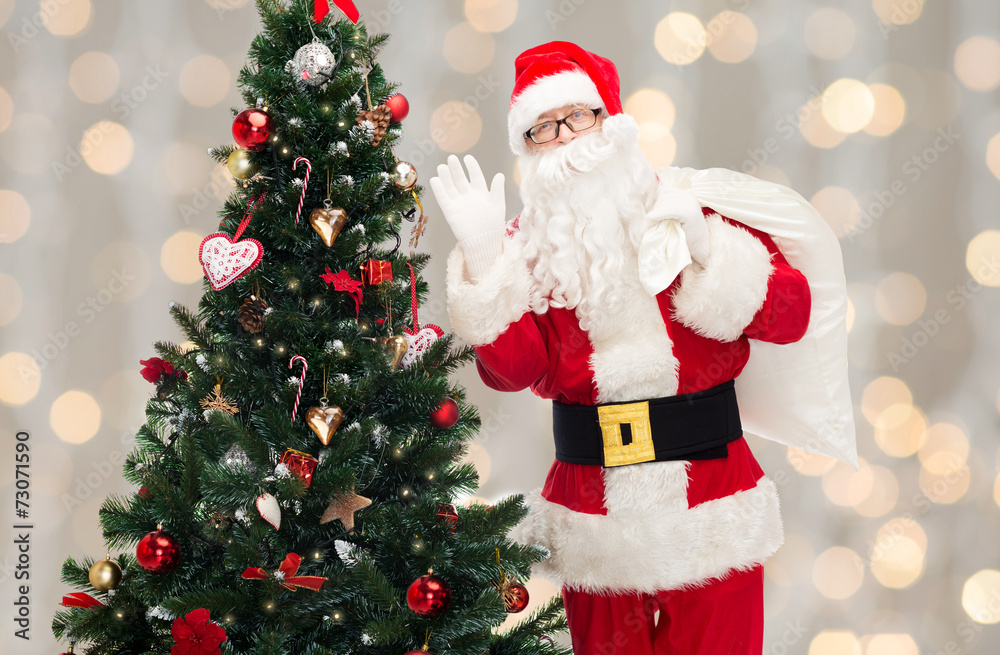 santa claus with bag and christmas tree