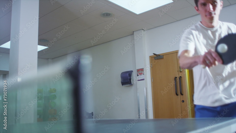 Young man playing table tennis confidently Young man playing table tennis confidently
