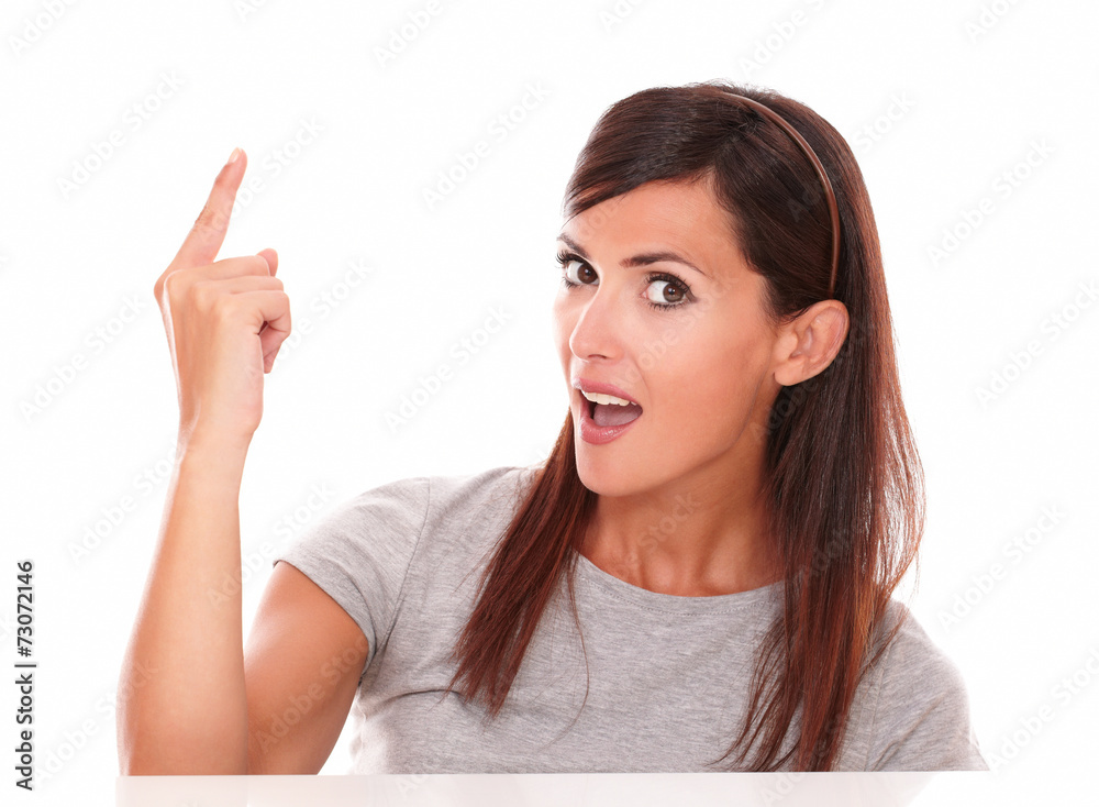 Hispanic lady pointing up and looking at camera Hispanic lady pointing up and looking at camera