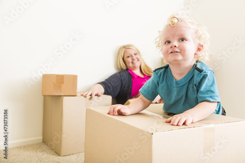 Happy Mother and Son in Empty Room with Moving Boxes