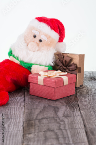 Santa Claus toy leaning against the gift boxes