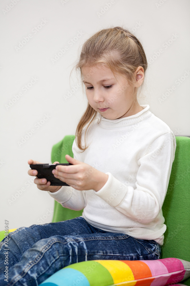 Pretty Caucasian girl playing game on cellphone, indoor Pretty Caucasian girl playing game on cellphone, indoor