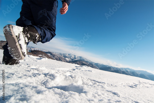 Mountaineer reaches the top of a snowy mountain.