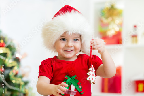 child girl in Santa hat hol...