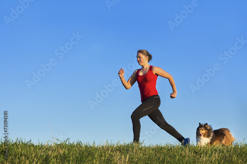 junge Fraue beim joggen mit Hund