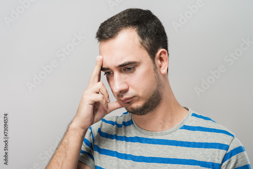 Depressed young man holding head in hands