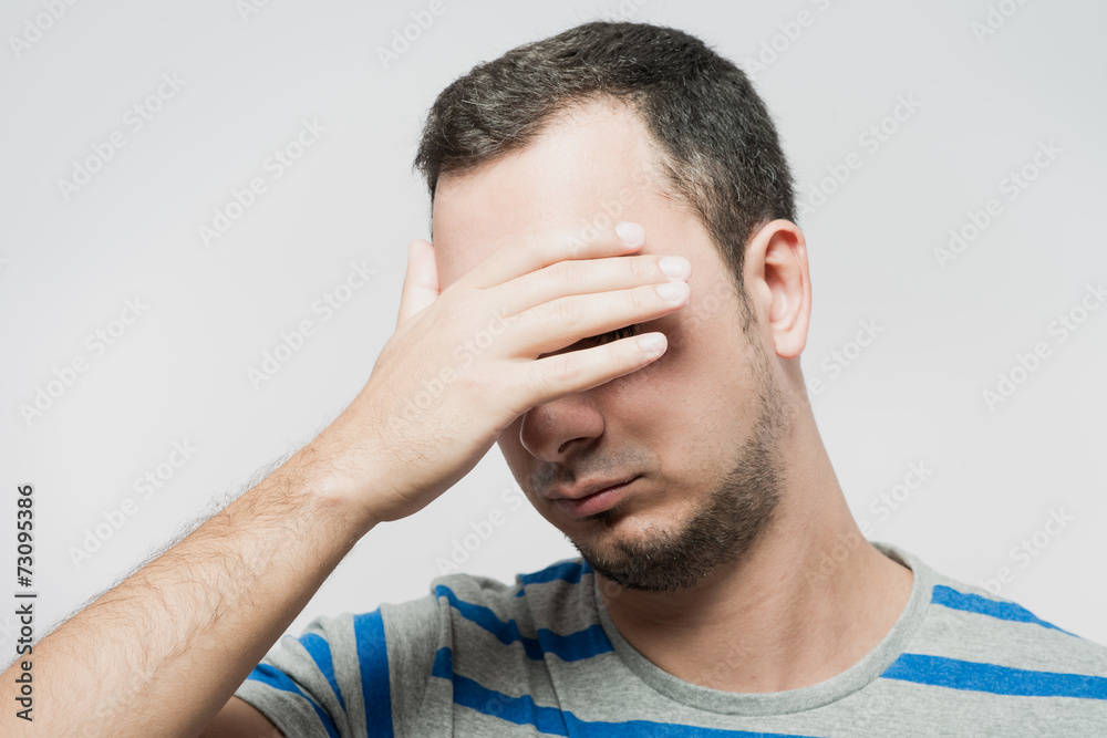 Fototapeta premium Depressed young man holding head in hands