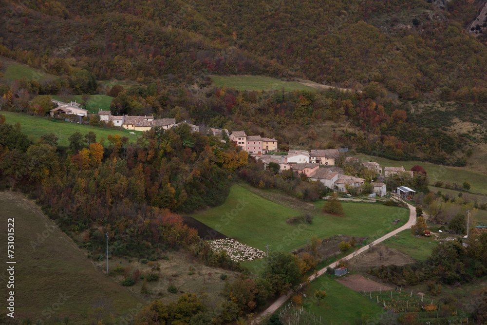Villaggio di montagna con pecore al pascolo