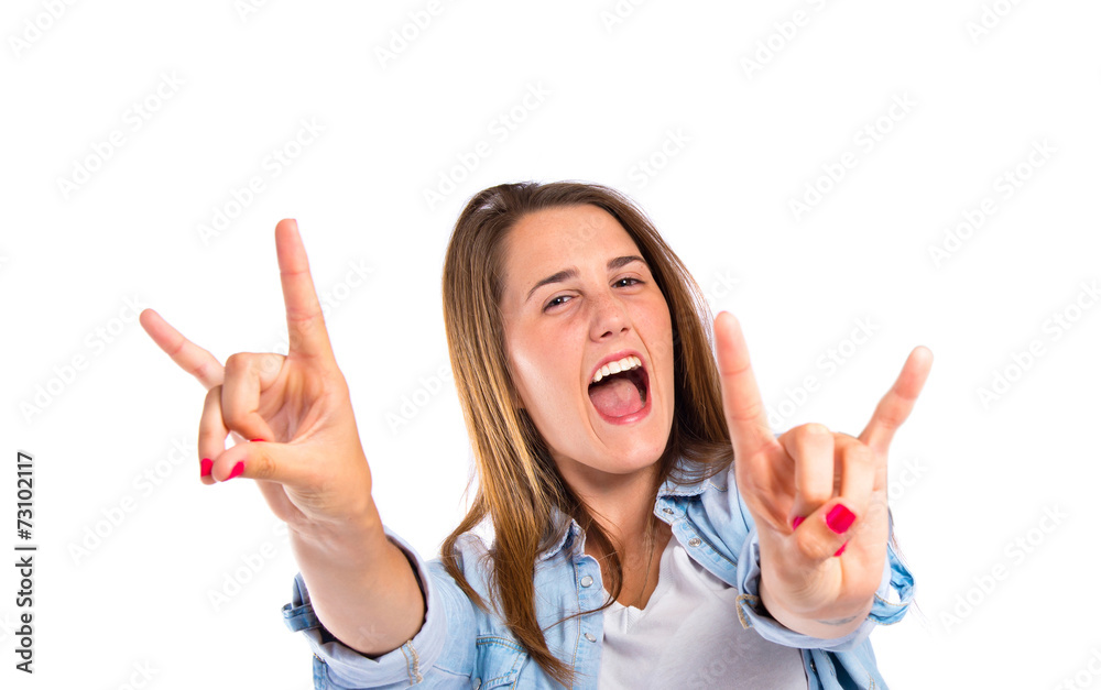 Girl making horn gesture over white background Girl making horn gesture over white background
