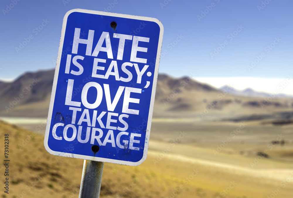 Hate is Easy Love Takes Courage sign with a desert