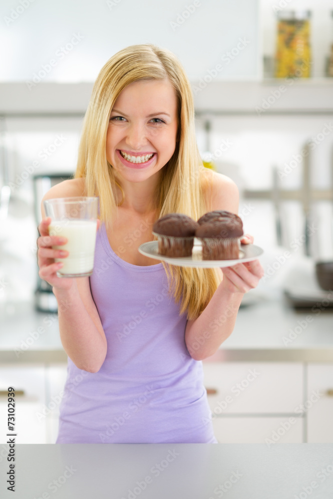 Portrait of happy teenager girl with muffin and milk in kitchen Portrait of happy teenager girl with muffin and milk in kitchen