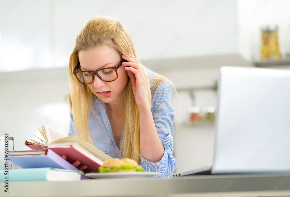 Young woman studying in kitchen Young woman studying in kitchen