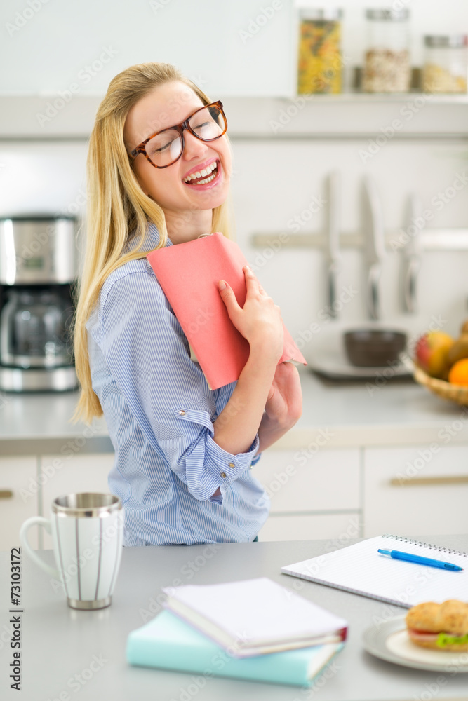 Portrait of happy young woman studying in kitchen Portrait of happy young woman studying in kitchen