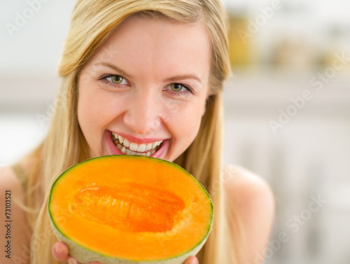 Portrait of happy young woman showing melon