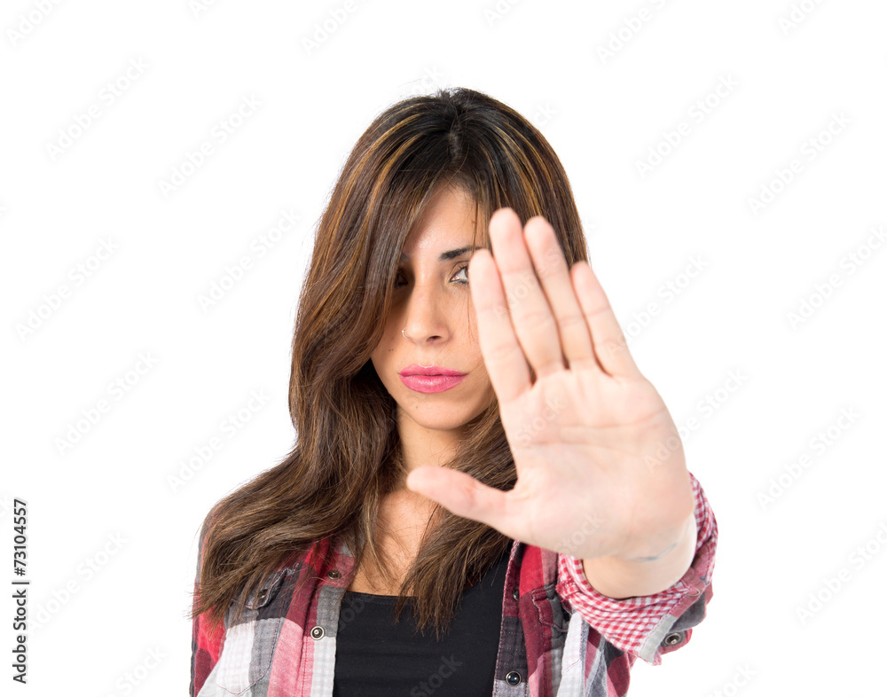 Girl making stop sign over white background Girl making stop sign over white background