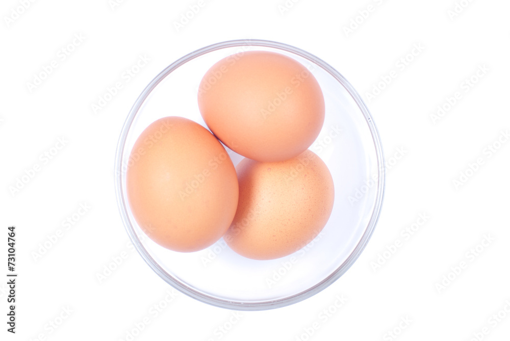 Three brown eggs in a glass bowl isolated on white background to Three brown eggs in a glass bowl isolated on white background to