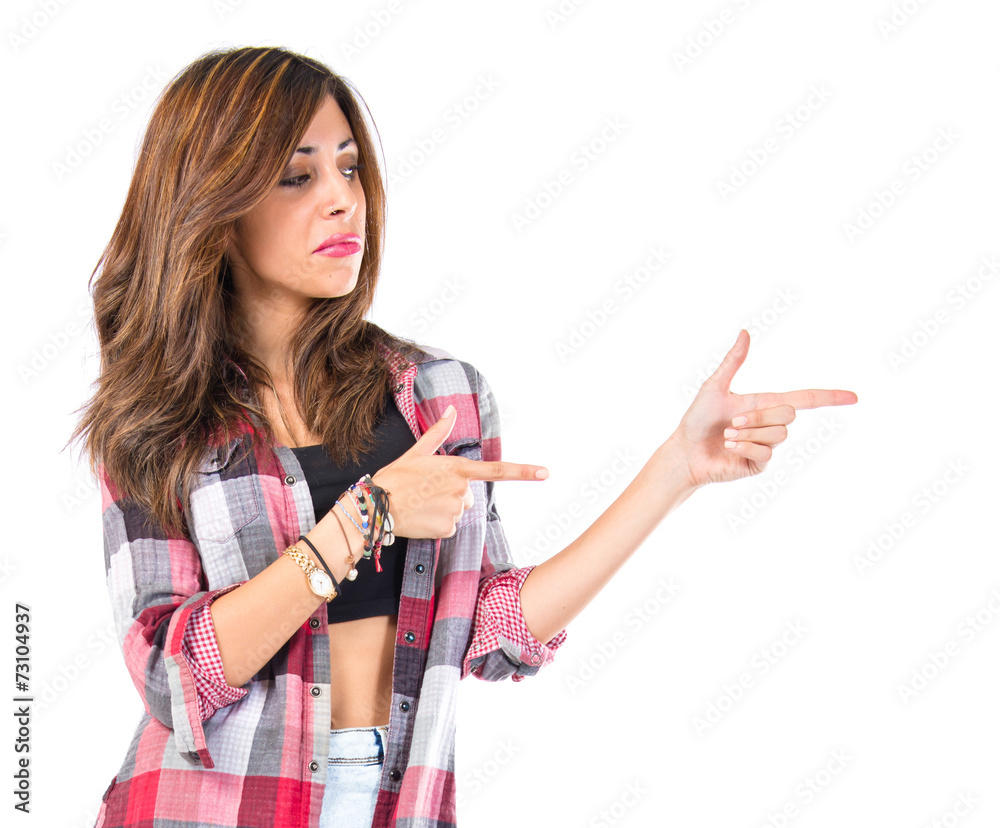 Girl pointing lateral over isolated white background Girl pointing lateral over isolated white background