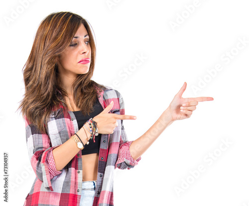 Girl pointing lateral over isolated white background