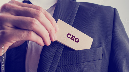 Businessman showing a card reading CEO photo