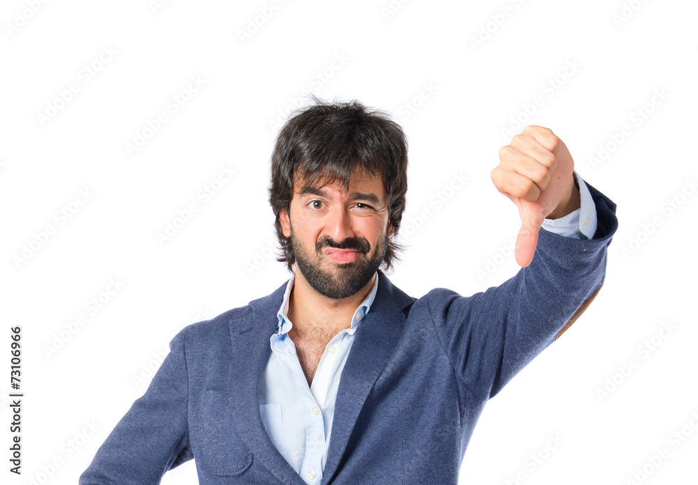 Businessman doing a bad signal over white background Businessman doing a bad signal over white background