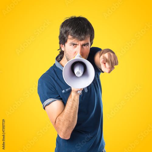Man shouting over isolated yellow background © luismolinero