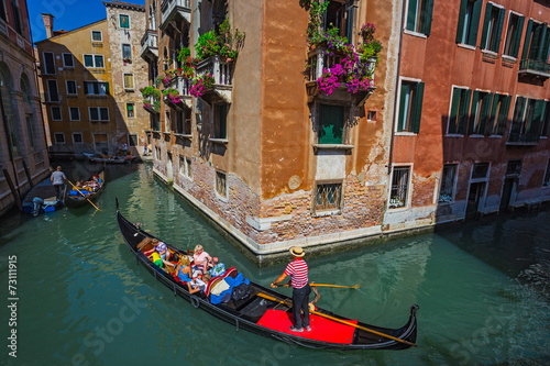 Tablou canvas Tourists travel on gondolas at canal