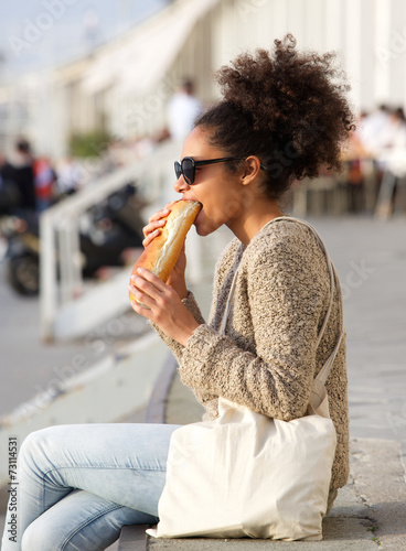 Young woman relaxing outdoors and eating food