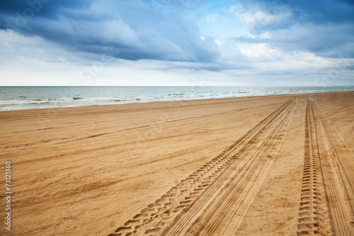 Fototapeta Naklejka Na Ścianę i Meble -  Perspective of tyre tracks on sandy beach