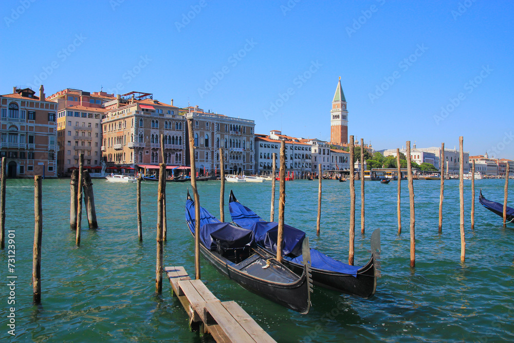 Venice, gondolas in the foreground anchored to the shore.