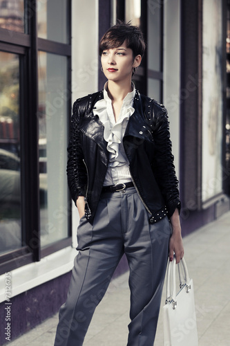 Happy young fashion woman in leather jacket with handbag