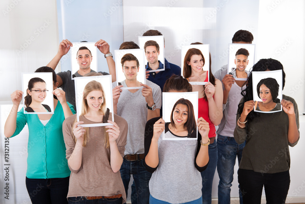 College Students Holding Photographs In Front Of Faces