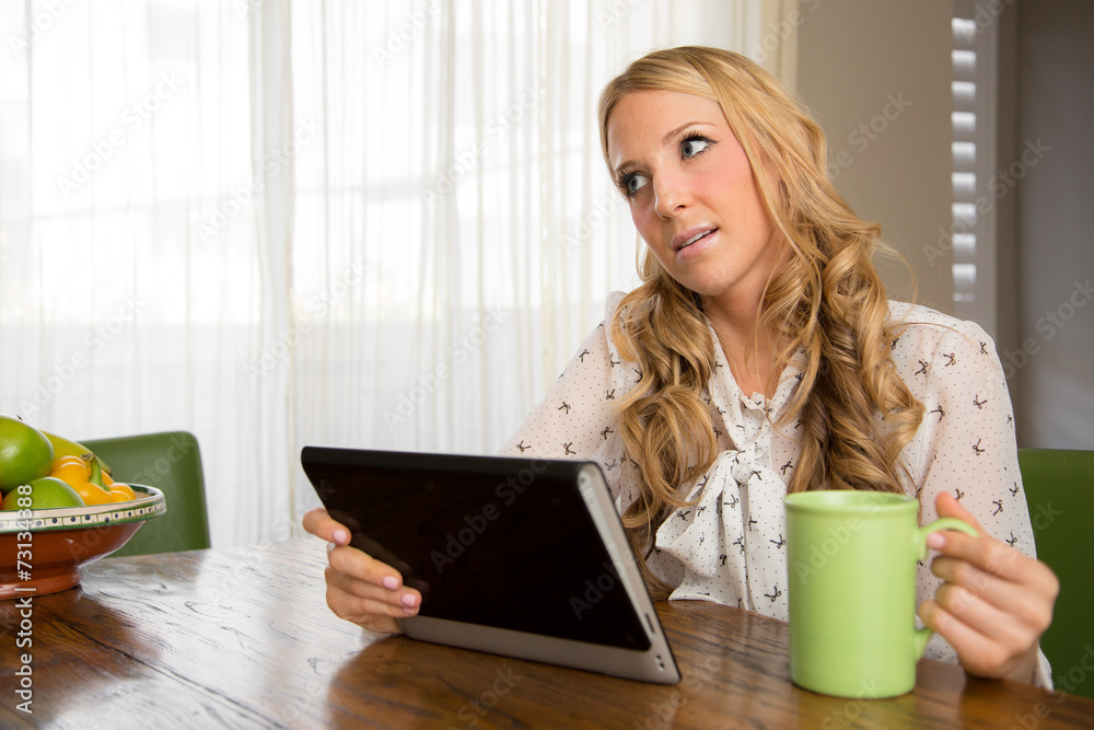 Female drinking coffee and reading the news on her tablet Female drinking coffee and reading the news on her tablet