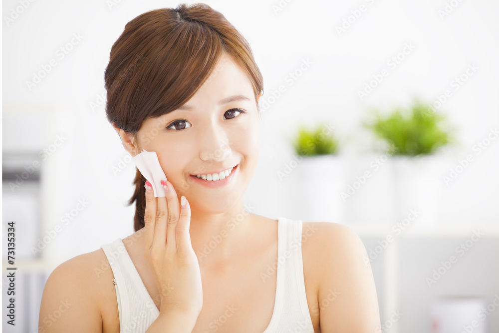 Beautiful asian young woman cleaning her face with cotton Beautiful asian young woman cleaning her face with cotton