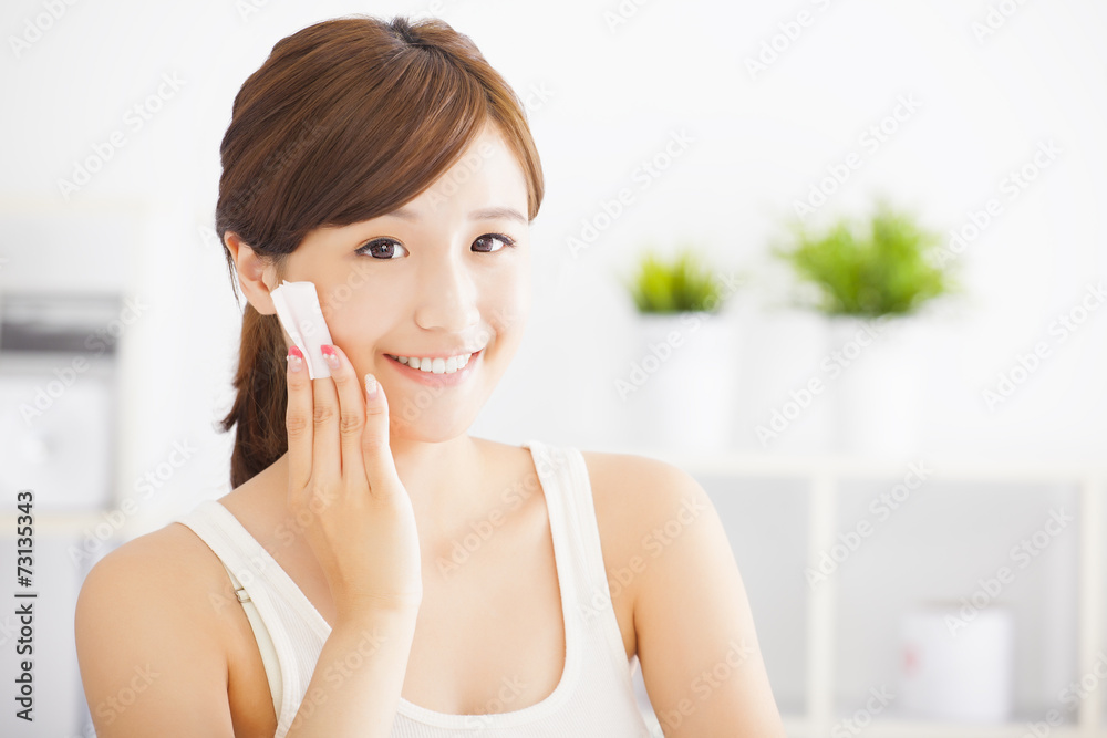 Beautiful asian young woman cleaning her face with cotton Beautiful asian young woman cleaning her face with cotton