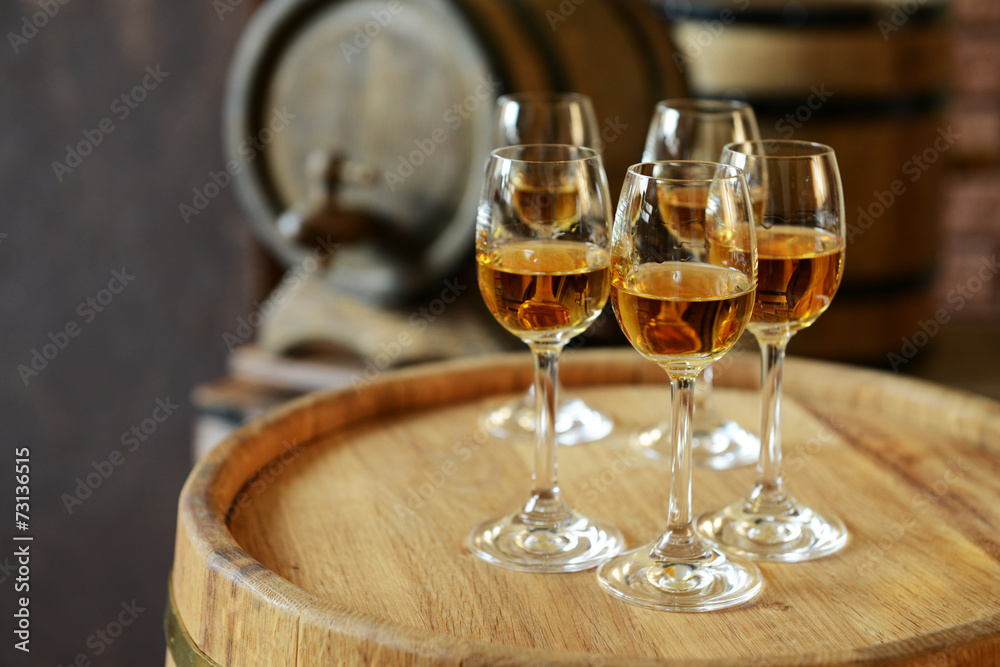 Glasses of wine in cellar with old barrels Glasses of wine in cellar with old barrels