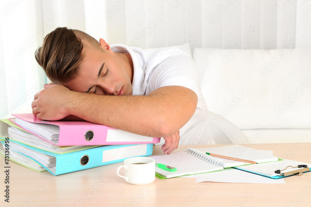 Tired man with many folders sleeps on table Tired man with many folders sleeps on table