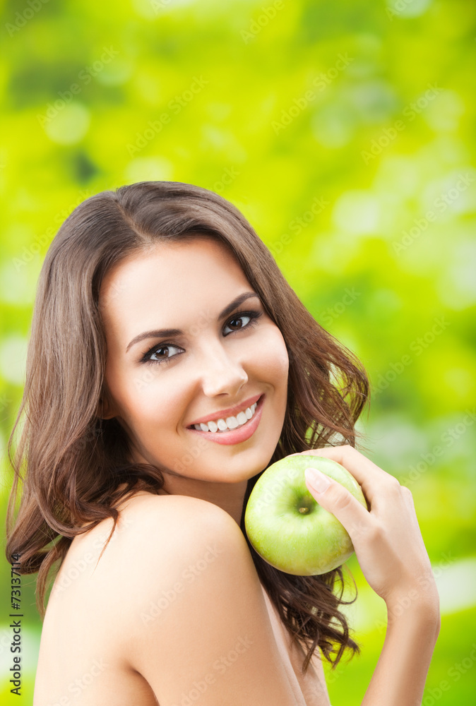 Young woman eating apple, outdoors Young woman eating apple, outdoors
