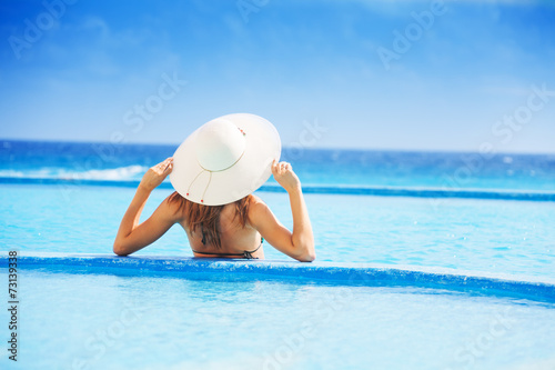 Back of young woman with white hat in the ocean © Sergey Novikov