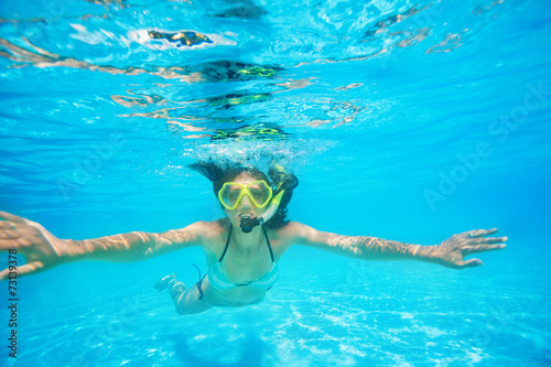 Woman wearing snorkeling mask swimming underwater