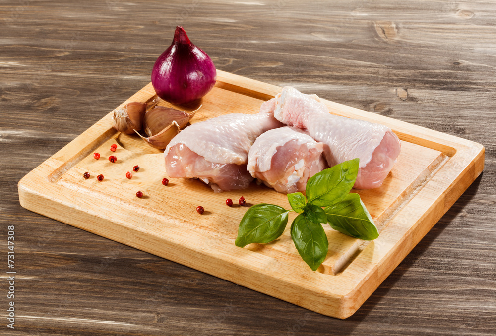 Raw chicken legs on cutting board Raw chicken legs on cutting board