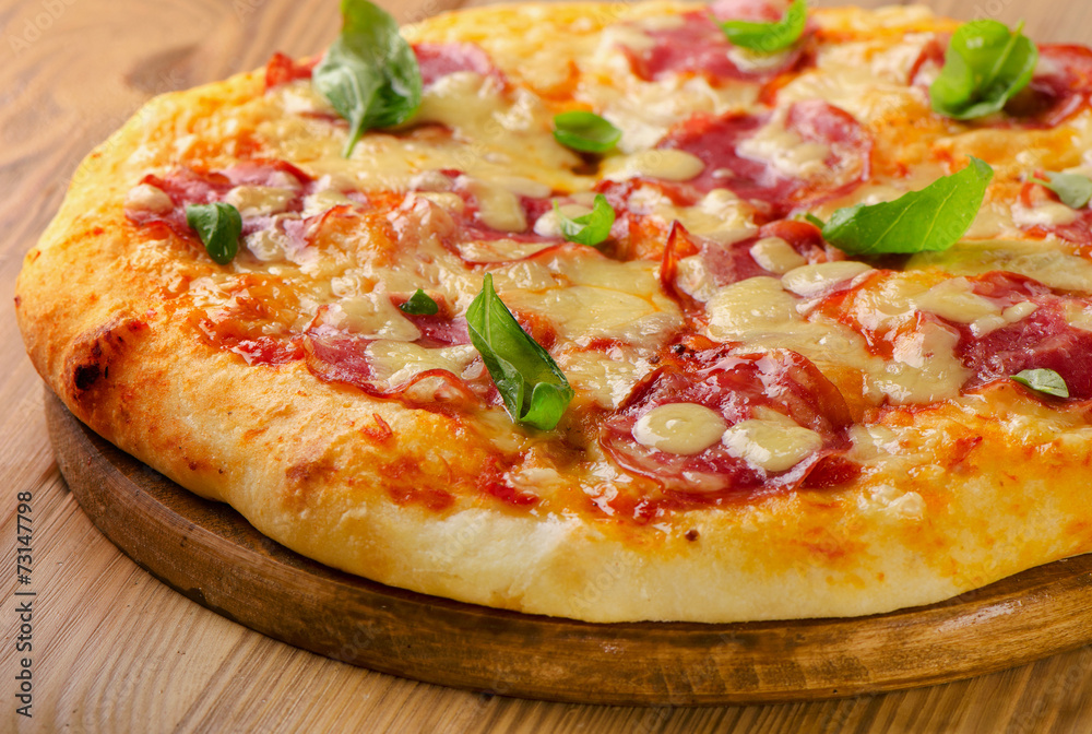 Salami pizza on a wooden  board