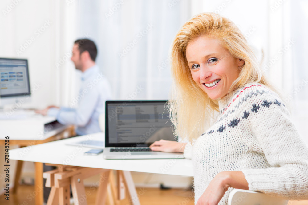 Young attractive blonde woman working on computer
