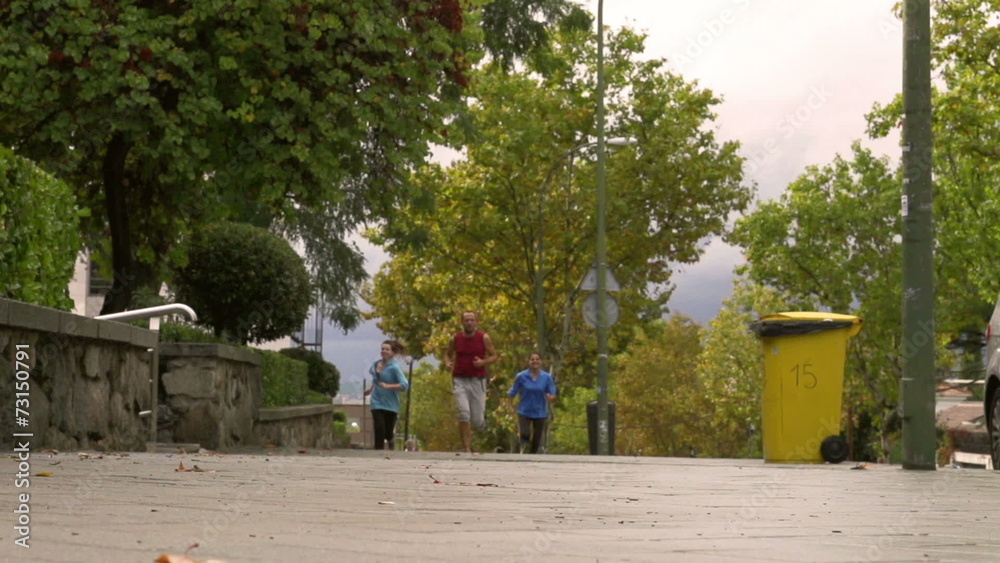 Three joggers racing in the city, slow motion 240fps, steadycam Three joggers racing in the city, slow motion 240fps, steadycam